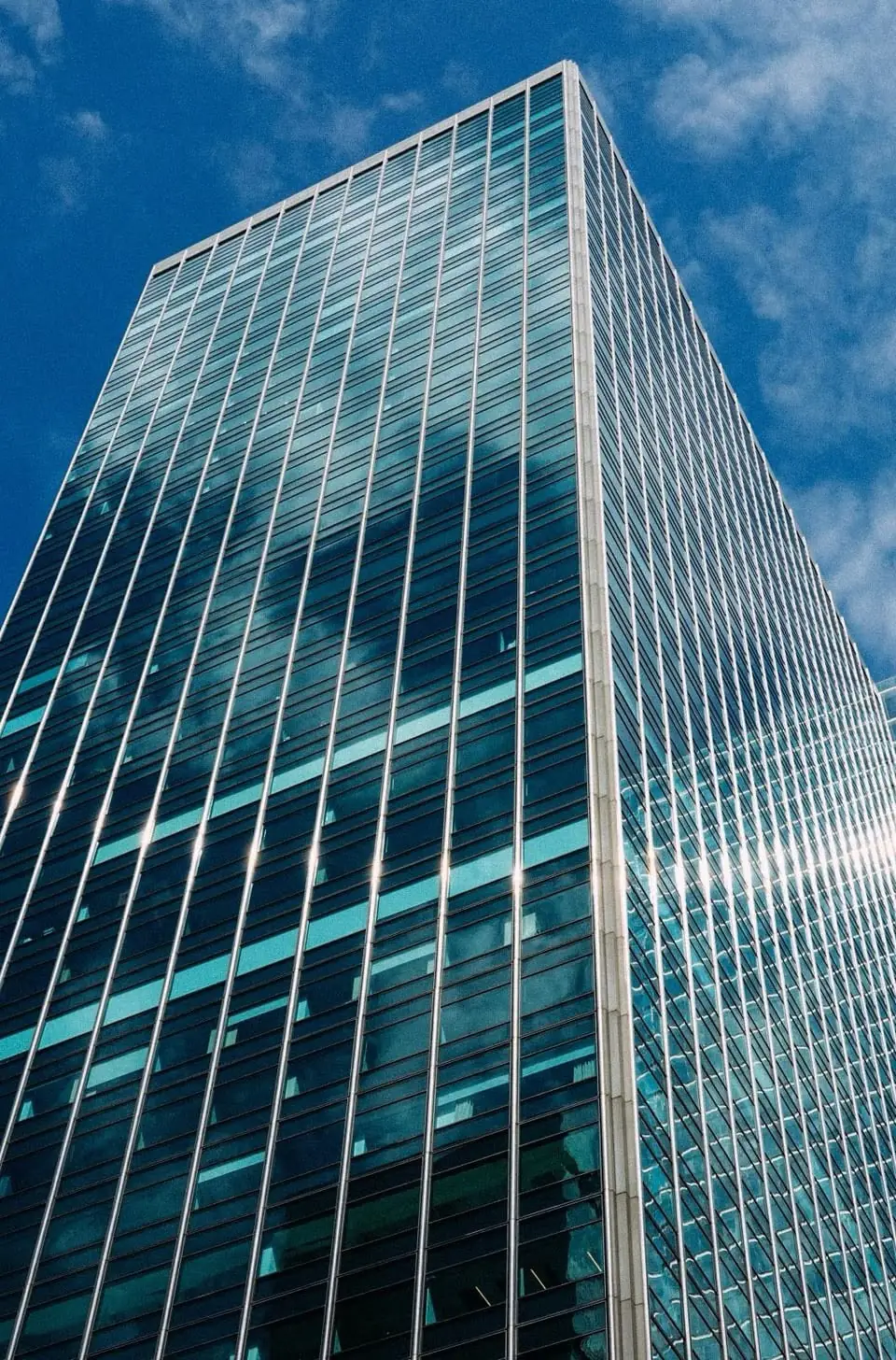 A blue glass Chicago office tower against a bright sky