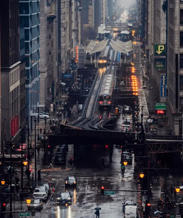 Elevated L tracks over a rainy downtown Chicago street