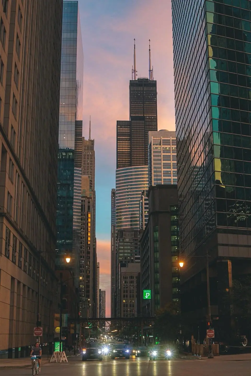 A downtown Chicago street at dusk with Willis Tower at the end of the block