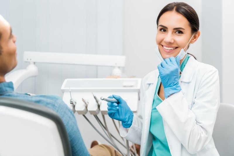 Dentist smiling beside a patient in a modern dental treatment room