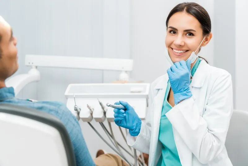 Dentist smiling beside a patient in a modern dental treatment room