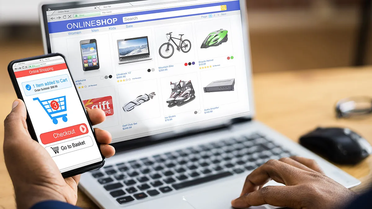 Shopper adding an item to the cart on a phone while browsing an online store on a laptop