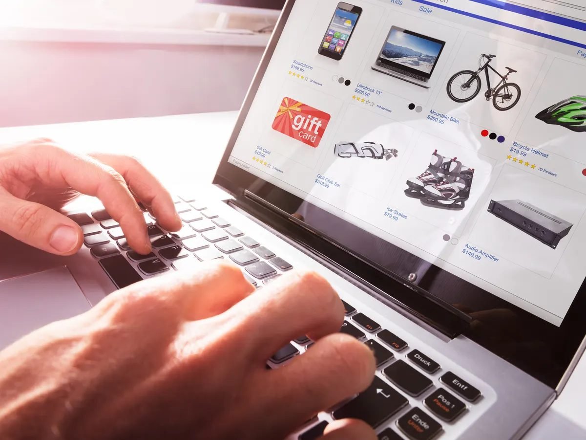 Shopper browsing an online product catalog with prices and star ratings on a laptop