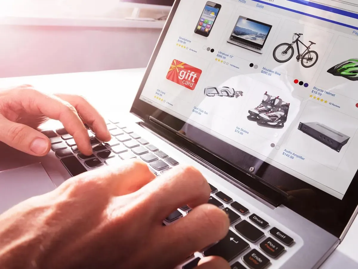 Shopper browsing an online product catalog with prices and star ratings on a laptop
