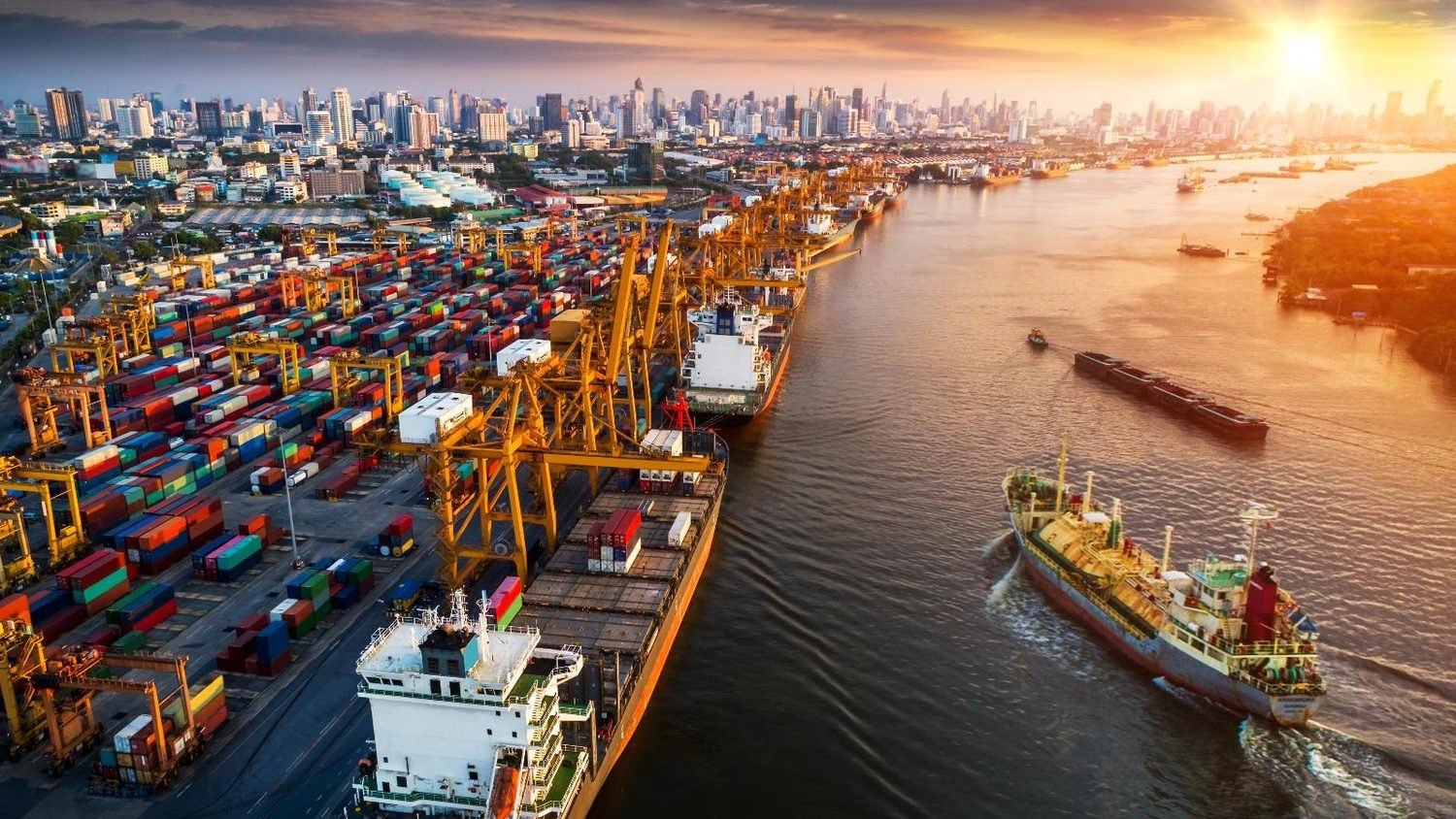 Aerial view of a container port at sunset with cranes and cargo vessels
