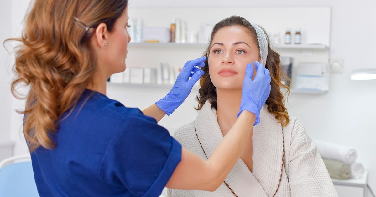 Aesthetic practitioner assessing a client before a facial treatment at a med spa