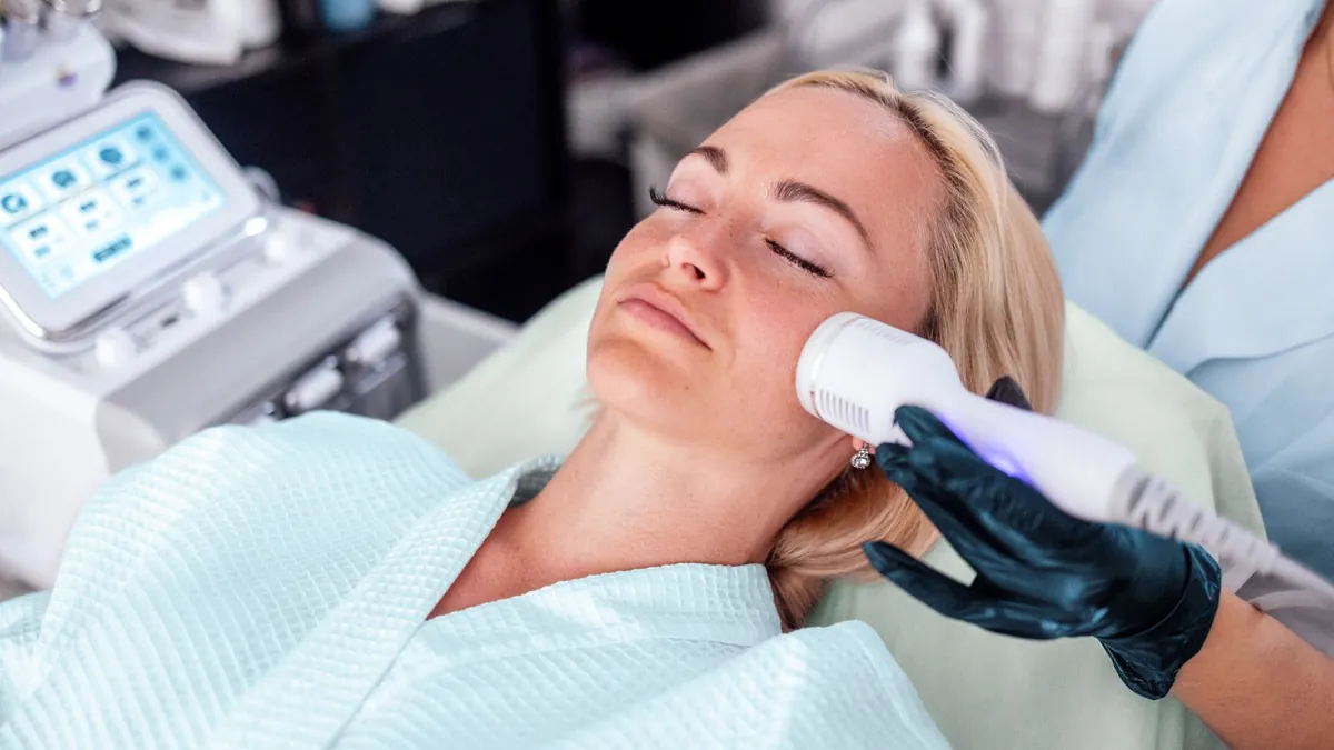 Client relaxing during a skin treatment with a handheld device at a med spa