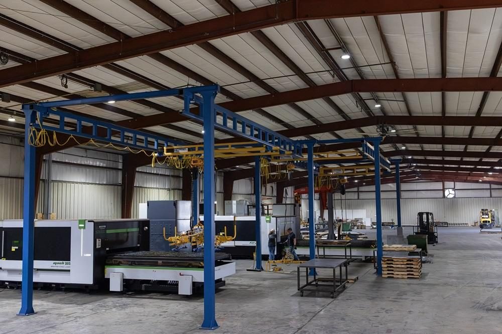 Fabrication shop floor with a fiber laser cutter and an overhead crane system