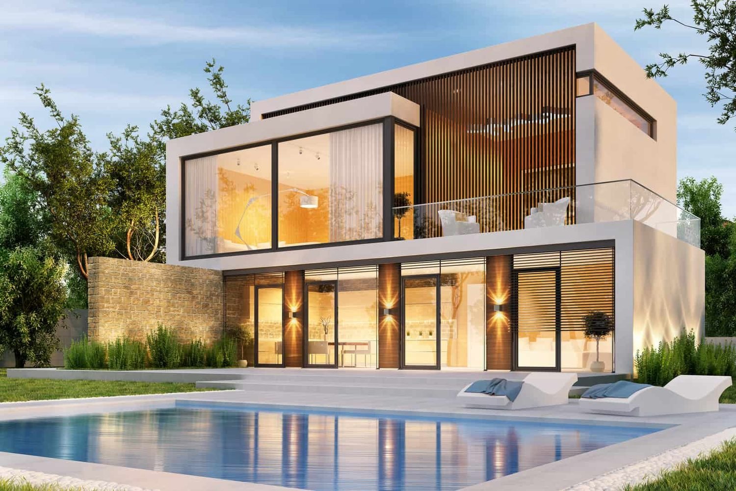 Modern architect designed home lit at dusk with a pool in the foreground
